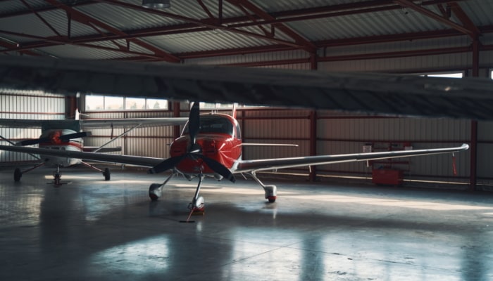 Two red and white planes in a dimly lit hangar