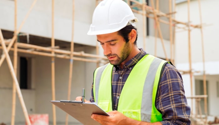 Construction worker looking at clipboard