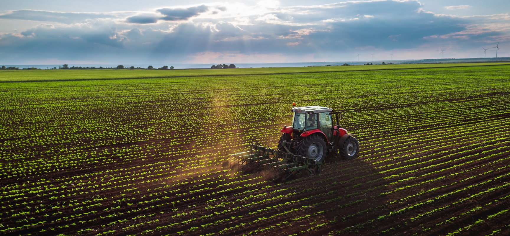 Red tractor plowing a field