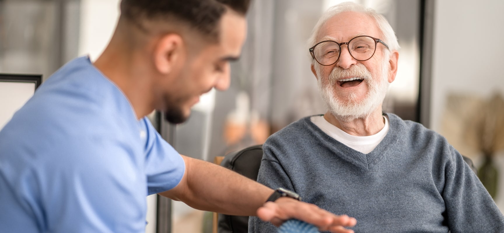 Elderly man laughing with nurse