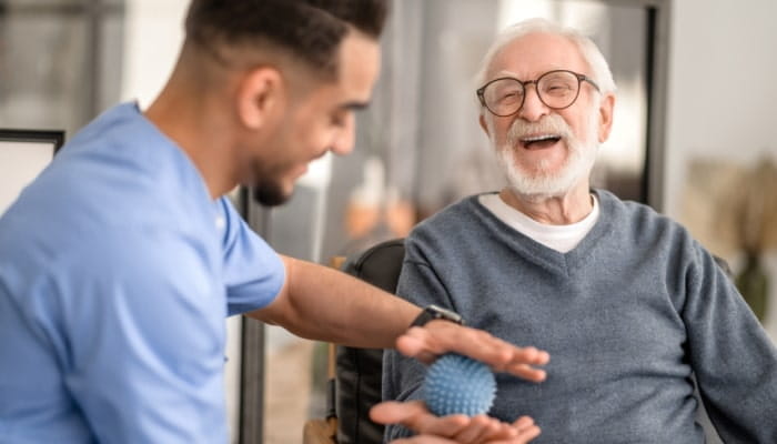 Elderly man laughing with nurse