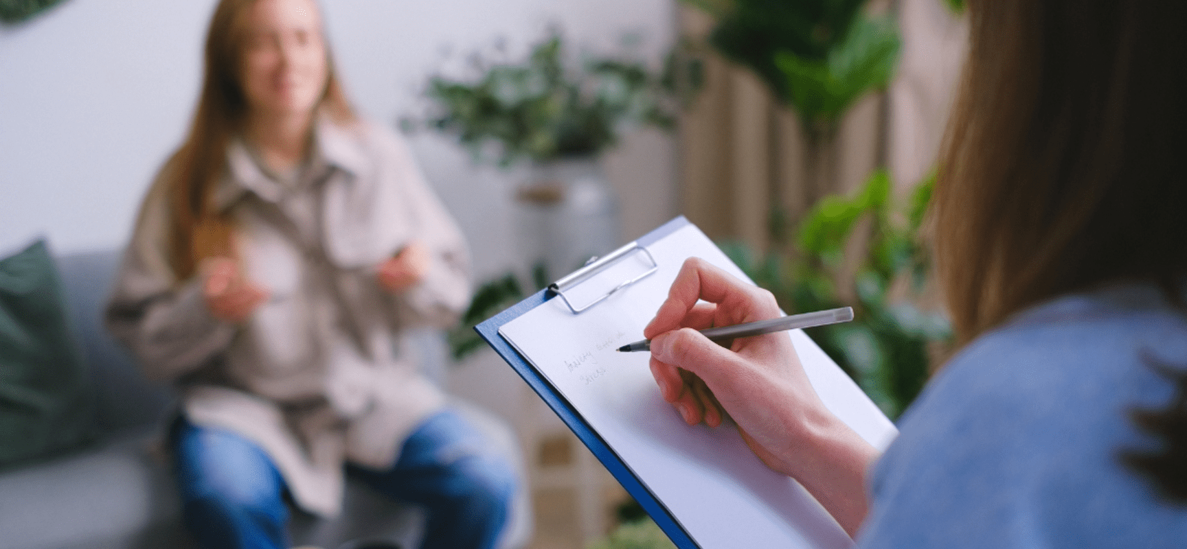 Two people talking with one writing on clipboard