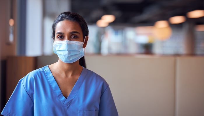 Medical professional in scrubs wearing a mask