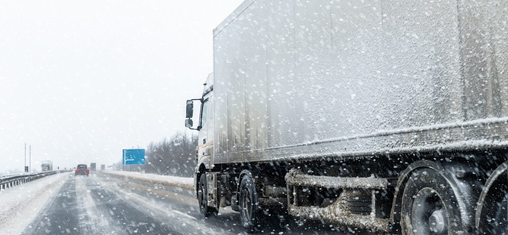 Semi-truck driving on snowy highway