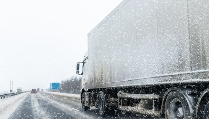 Semi-truck driving on snowy highway