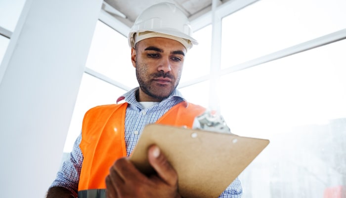 Construction worker looking at clipboard