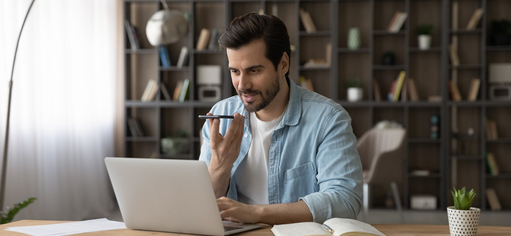 Man talking on phone in front of laptop