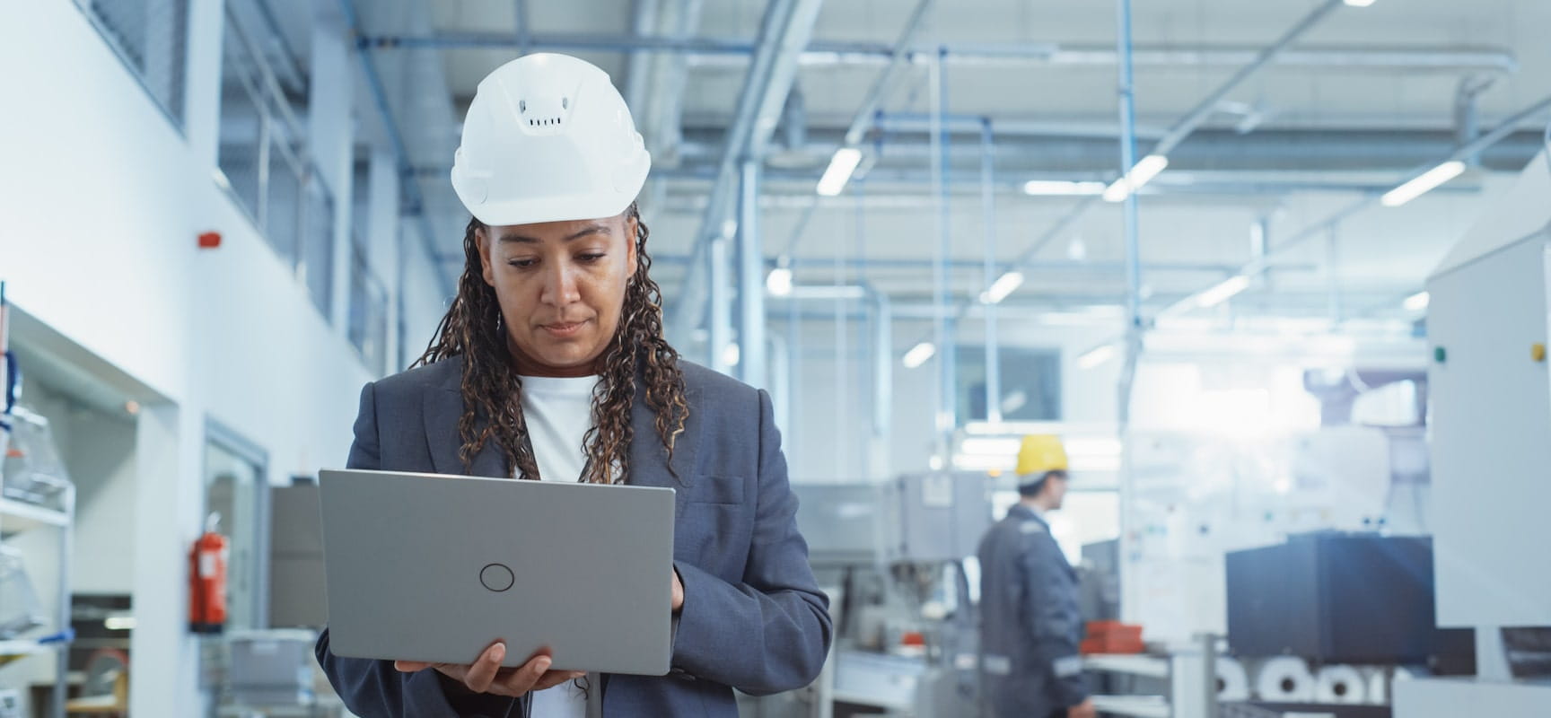 Woman in a hardhat holding a laptop