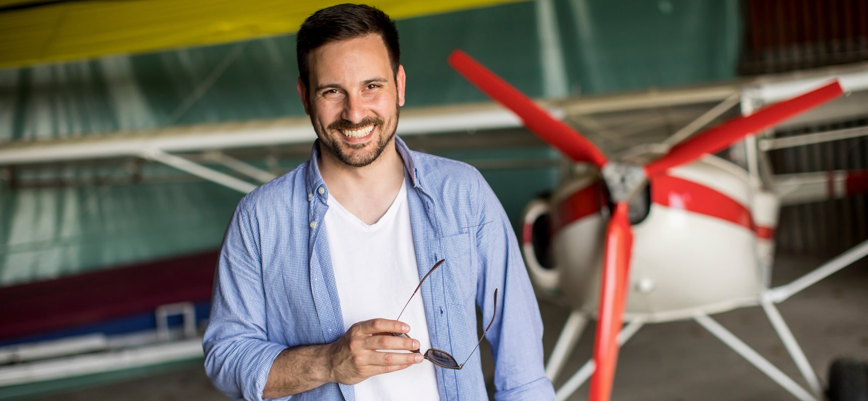Man smiling in front of plane