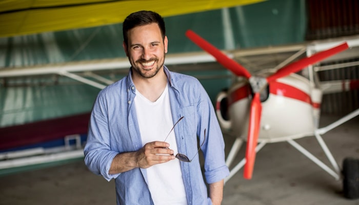 Man smiling in front of plane
