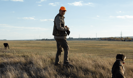 AssuredPartners Outdoor Insurance Hunt Club page featuring an image of hunters in a wooded area, with text highlighting insurance coverage options for hunt clubs, a navigation menu, and links to get a quote or contact the company.